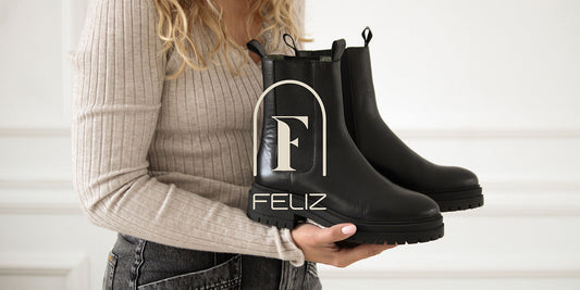 Girl holding black leather boots from Feliz Shoes